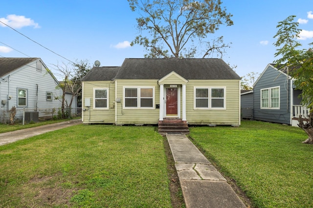 bungalow-style house featuring central AC and a front lawn