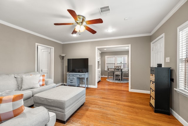 living room with light hardwood / wood-style flooring, ceiling fan, and ornamental molding