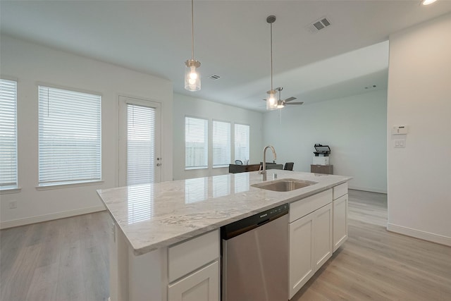 kitchen featuring dishwasher, a kitchen island with sink, sink, light stone countertops, and white cabinetry