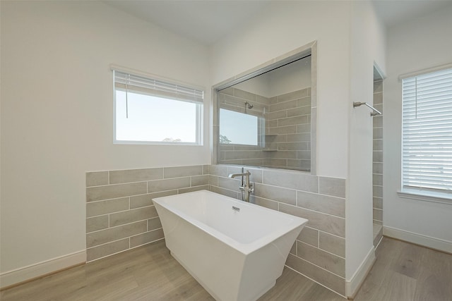 bathroom with separate shower and tub, sink, wood-type flooring, and tile walls