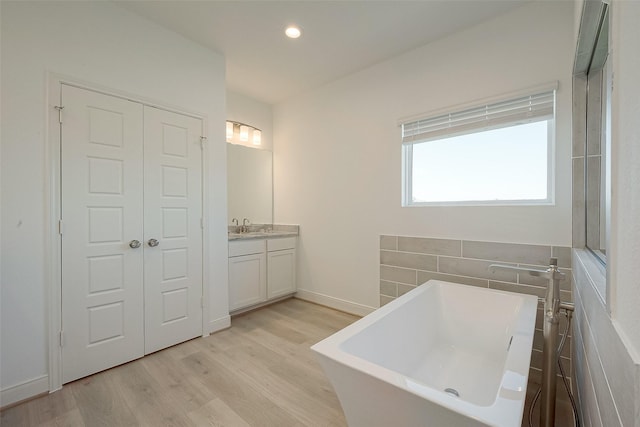 bathroom featuring a bathtub, vanity, and hardwood / wood-style flooring