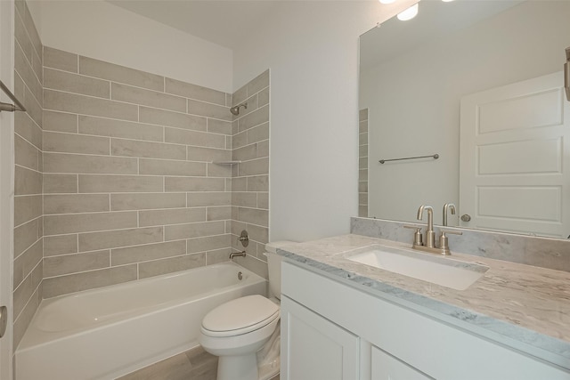 full bathroom featuring hardwood / wood-style flooring, tiled shower / bath combo, toilet, and vanity