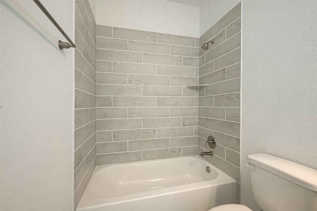 bathroom featuring toilet and tiled shower / bath