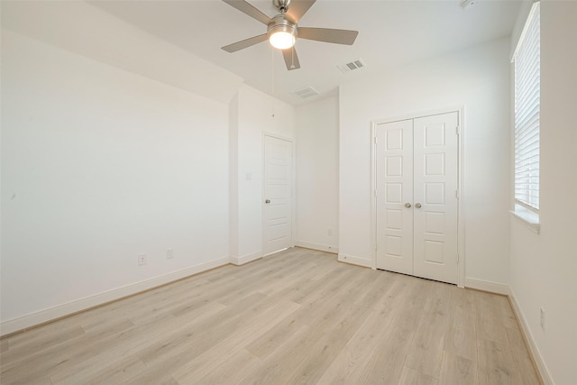 unfurnished bedroom with light wood-type flooring, a closet, and ceiling fan