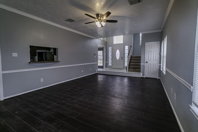 unfurnished living room featuring crown molding, ceiling fan, dark hardwood / wood-style floors, and a textured ceiling