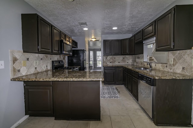 kitchen featuring black appliances, sink, dark stone countertops, light tile patterned flooring, and kitchen peninsula