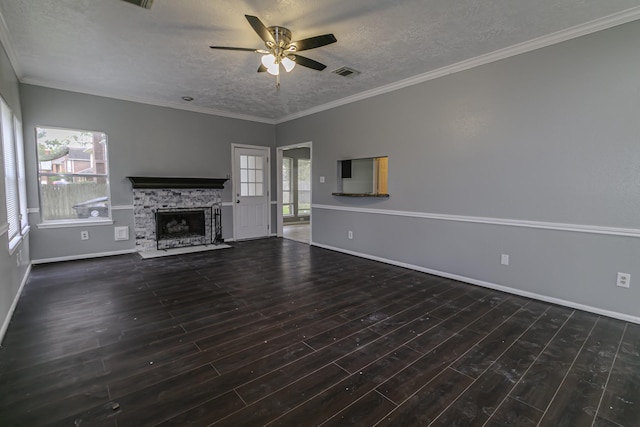 unfurnished living room featuring ceiling fan, dark hardwood / wood-style flooring, a stone fireplace, and crown molding