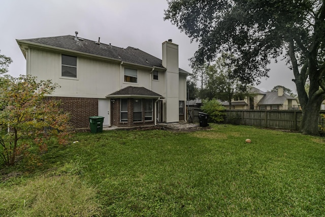 back of house featuring a lawn