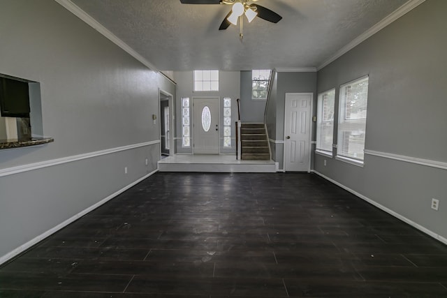 entryway with a textured ceiling, ceiling fan, and crown molding