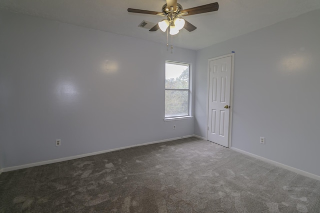 empty room with dark colored carpet and ceiling fan