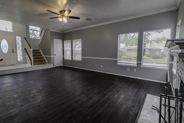 unfurnished living room featuring ceiling fan, a stone fireplace, a textured ceiling, and dark wood-type flooring