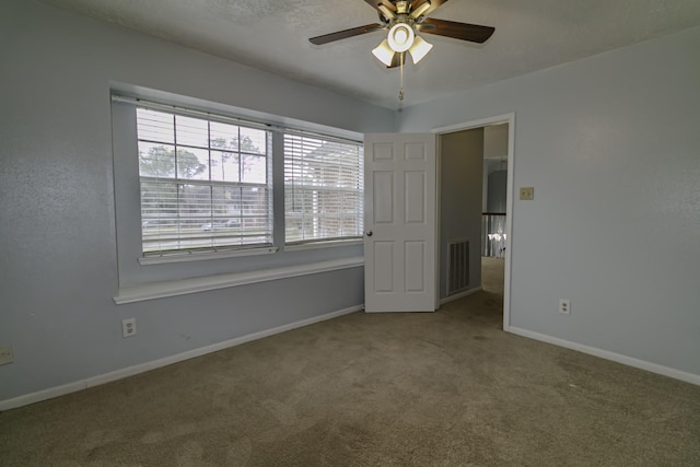 carpeted spare room featuring ceiling fan