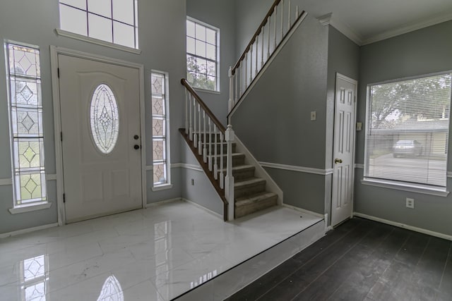 foyer entrance featuring a healthy amount of sunlight and ornamental molding