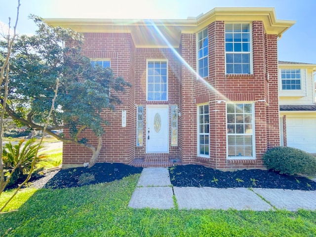 view of front of property with a garage and brick siding