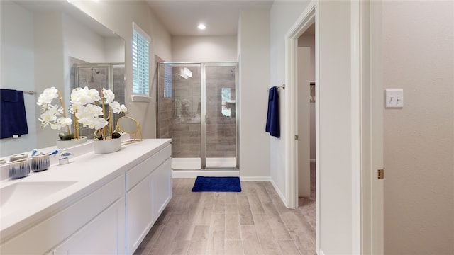 bathroom featuring a shower with door, vanity, and wood-type flooring