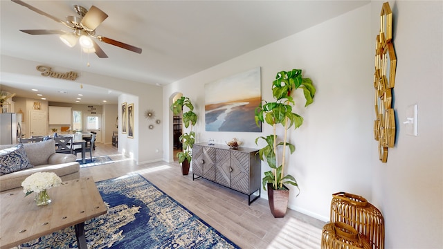 living room with ceiling fan and light hardwood / wood-style flooring