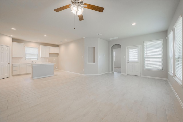 unfurnished living room featuring ceiling fan and light hardwood / wood-style flooring