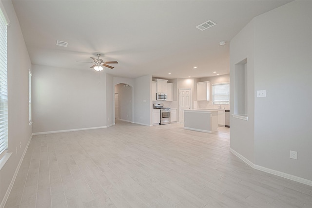 unfurnished living room with light hardwood / wood-style flooring and ceiling fan