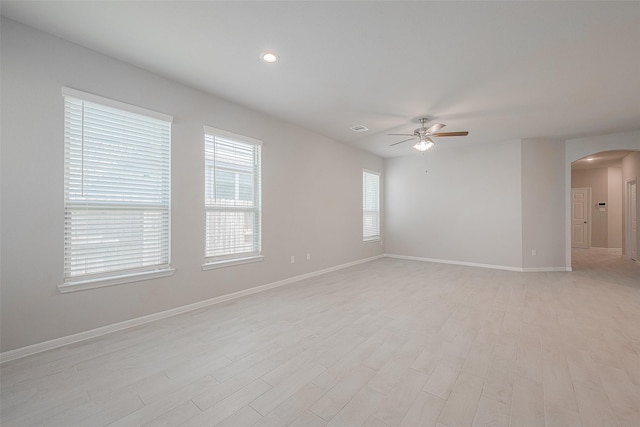 empty room with ceiling fan and light hardwood / wood-style flooring