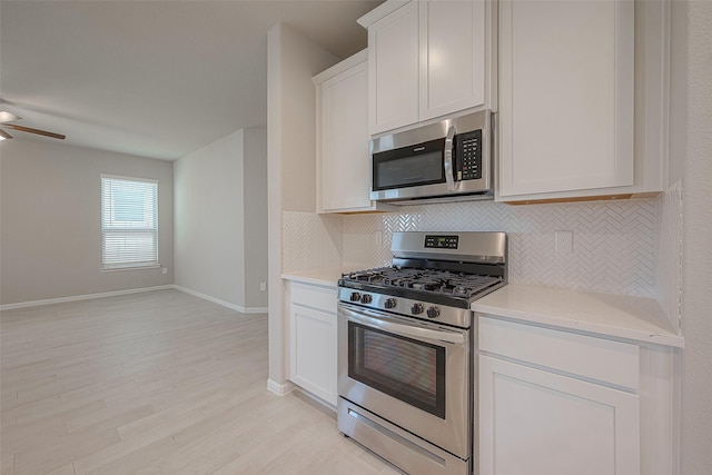 kitchen with white cabinets, light hardwood / wood-style flooring, ceiling fan, tasteful backsplash, and stainless steel appliances