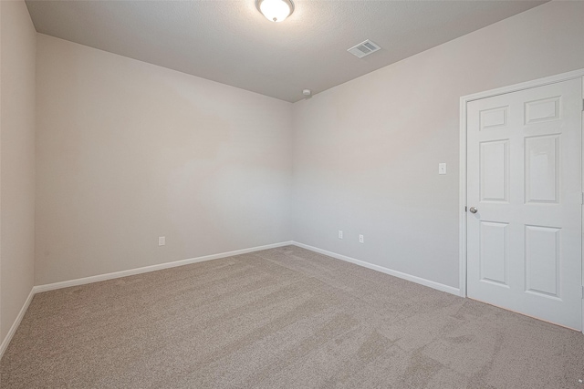 unfurnished room with carpet flooring and a textured ceiling