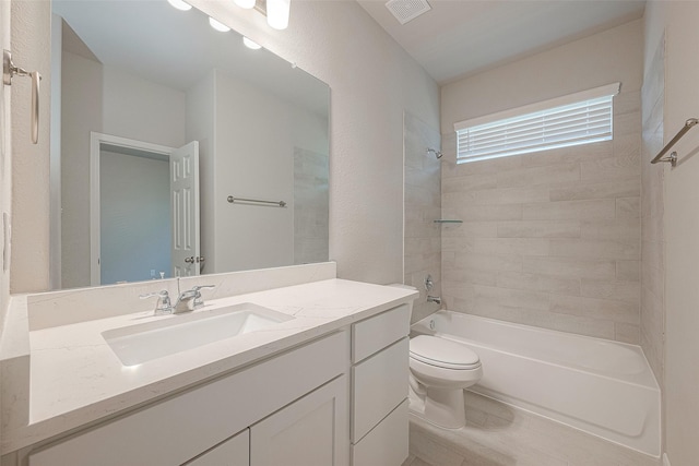 full bathroom featuring tiled shower / bath combo, toilet, and vanity