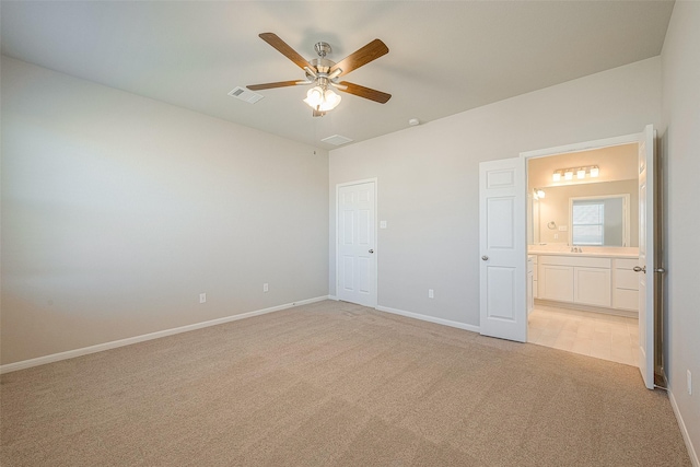 unfurnished bedroom featuring connected bathroom, ceiling fan, sink, and light colored carpet