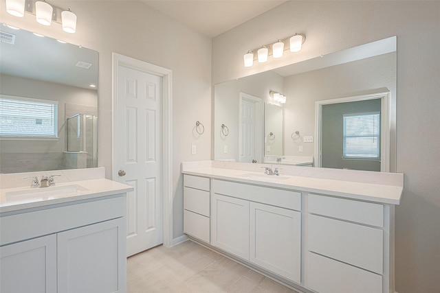 bathroom featuring plenty of natural light, a shower with door, and vanity