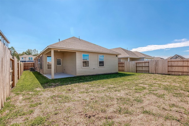 back of property with a lawn, a patio, and central AC unit