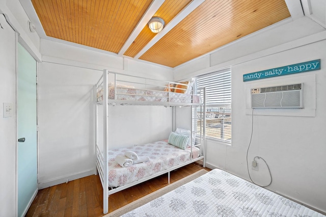 bedroom featuring a wall mounted AC, hardwood / wood-style floors, and wooden ceiling