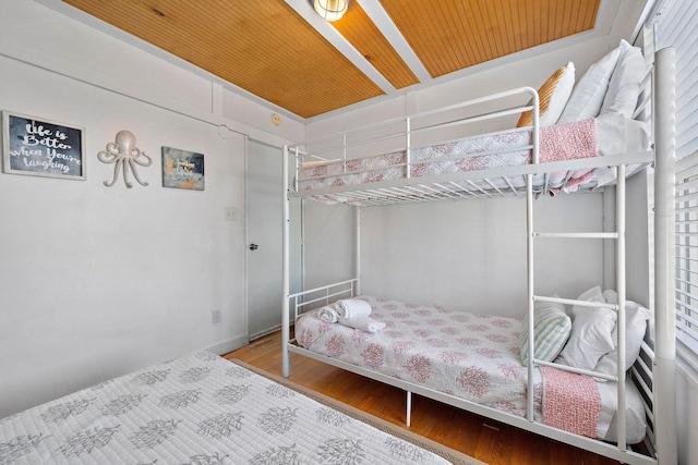 bedroom featuring hardwood / wood-style floors and wood ceiling