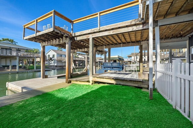 dock area with a lawn and a water view