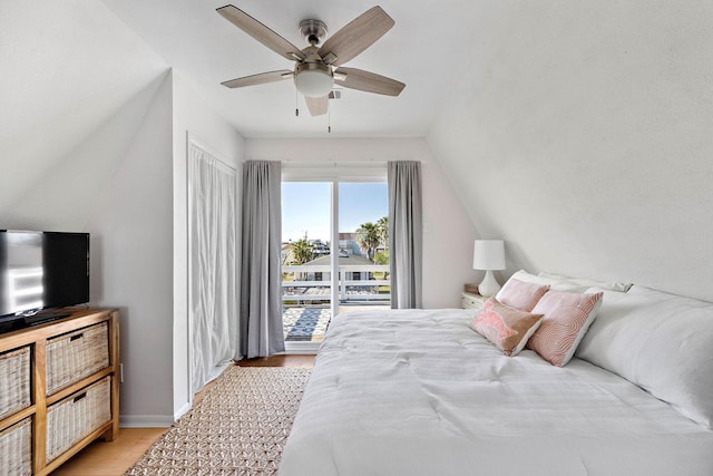 bedroom with ceiling fan, light hardwood / wood-style floors, and vaulted ceiling