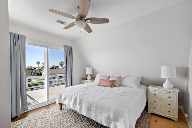 bedroom with access to exterior, ceiling fan, wood-type flooring, and vaulted ceiling