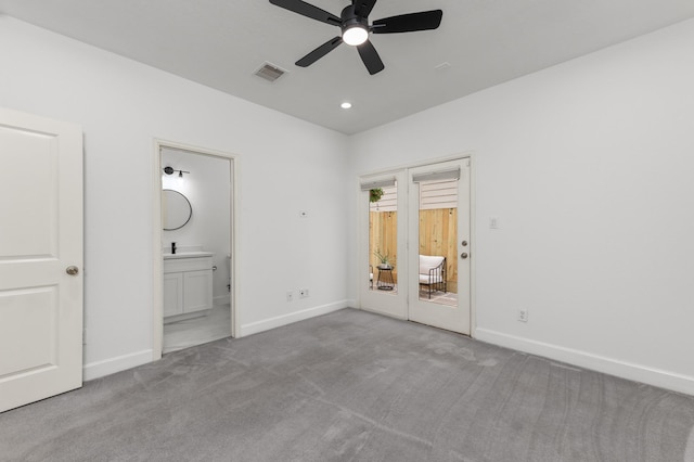 unfurnished bedroom featuring light carpet, ensuite bath, and ceiling fan