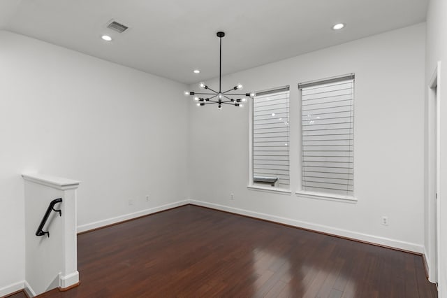 unfurnished dining area featuring a notable chandelier and dark hardwood / wood-style floors