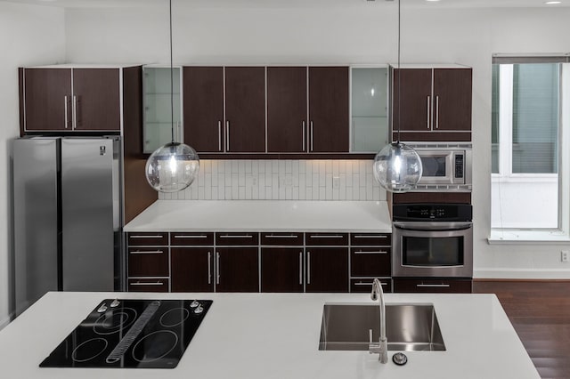 kitchen with dark hardwood / wood-style flooring, sink, hanging light fixtures, and appliances with stainless steel finishes