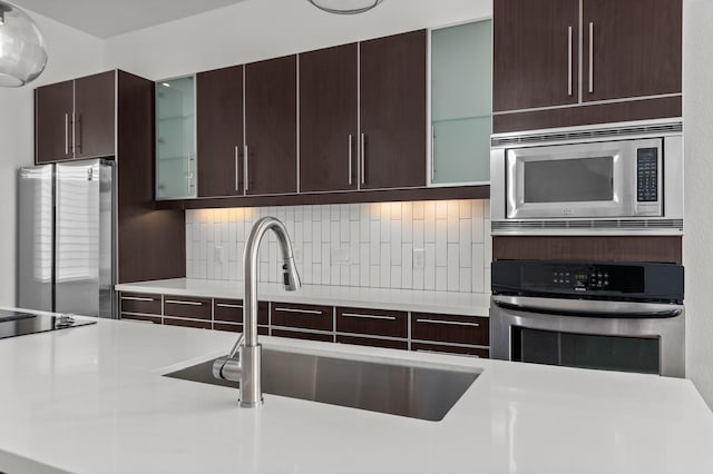 kitchen featuring decorative backsplash, sink, and appliances with stainless steel finishes