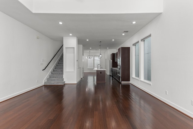 unfurnished living room featuring dark hardwood / wood-style flooring and sink