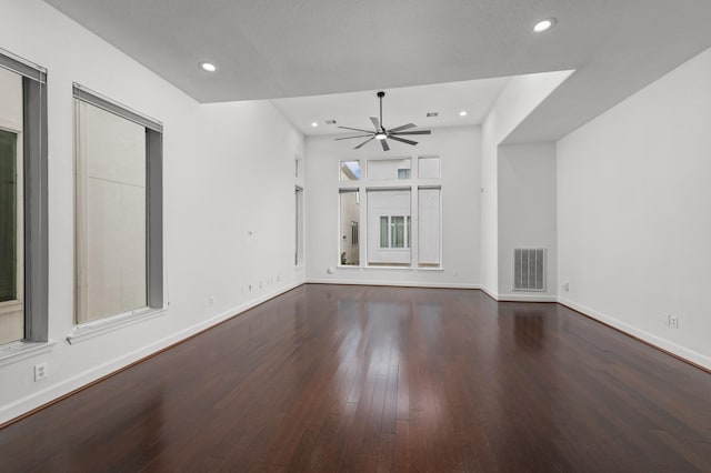 unfurnished living room featuring ceiling fan and dark wood-type flooring