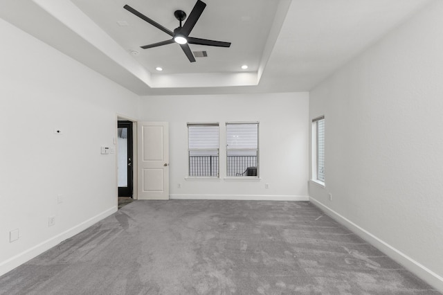 unfurnished room with carpet flooring, ceiling fan, and a tray ceiling