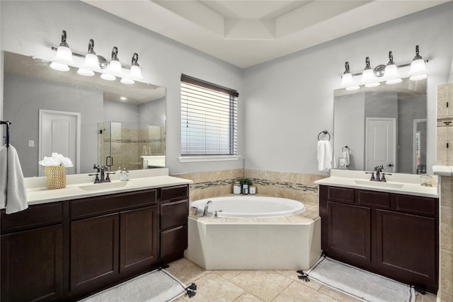 bathroom with tile patterned flooring, vanity, a raised ceiling, and independent shower and bath