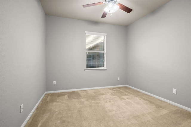 spare room with ceiling fan and light colored carpet