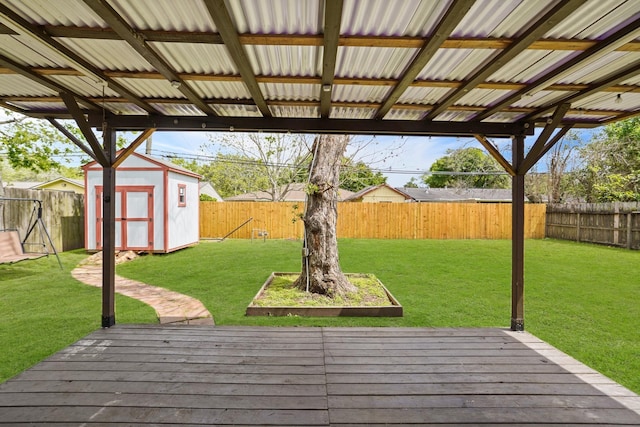 wooden terrace featuring a yard and a storage shed