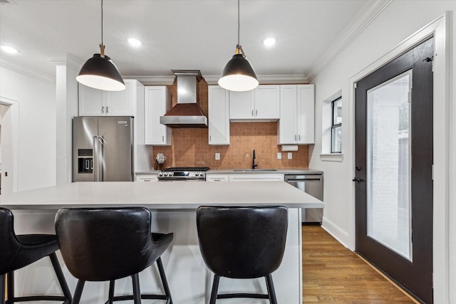 kitchen with white cabinets, premium range hood, stainless steel appliances, and hanging light fixtures