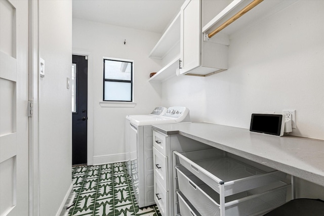 clothes washing area featuring washer and dryer and cabinets