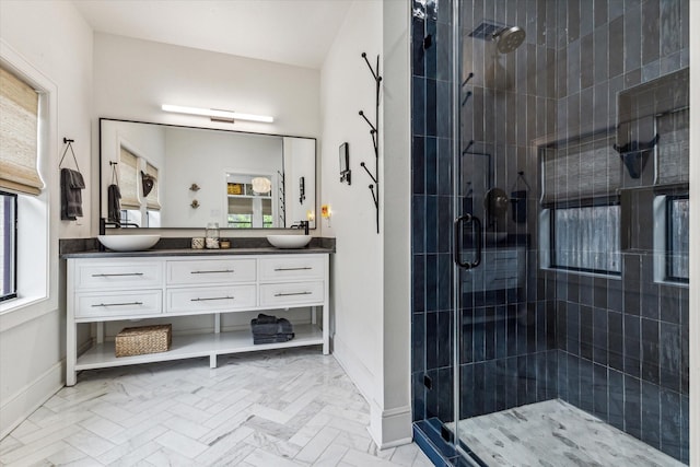 bathroom featuring vanity, a healthy amount of sunlight, and a shower with shower door