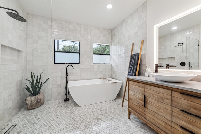 bathroom with tile patterned flooring, vanity, tile walls, and independent shower and bath