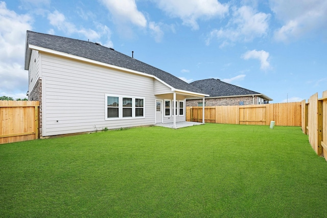 back of house with a patio area and a yard