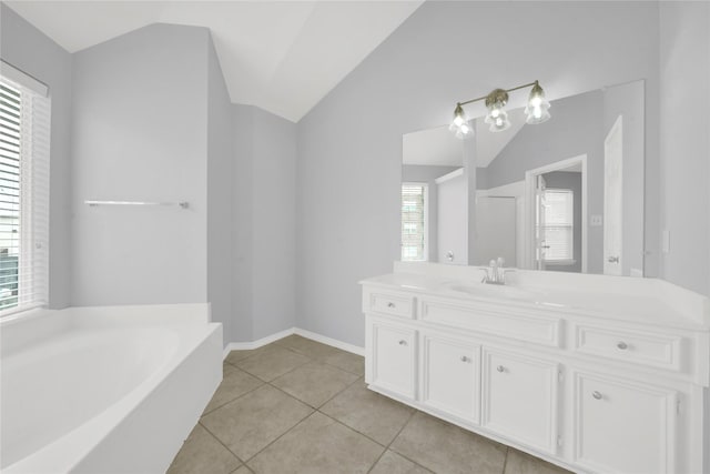 bathroom featuring tile patterned flooring, vanity, a tub, and lofted ceiling